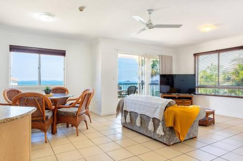 a living room with a bed and a dining room with a table at Ocean View Villa in Yeppoon