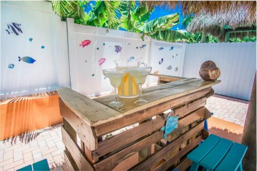 two martini glasses on top of a wooden table at Tiki Time! Pool-tiki Hut-kayaks-grill-ocean View! in Marathon