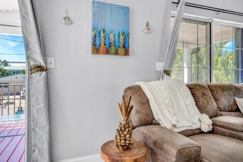 a living room with a couch and a table at Tiki Time! Pool-tiki Hut-kayaks-grill-ocean View! in Marathon
