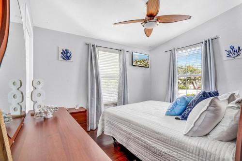 a bedroom with a bed and a ceiling fan at Tiki Time! Pool-tiki Hut-kayaks-grill-ocean View! in Marathon
