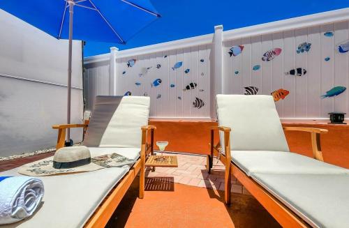 a balcony with two chairs and an umbrella at Tiki Time! Pool-tiki Hut-kayaks-grill-ocean View! in Marathon