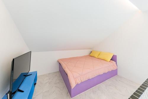 a small bedroom with a bed and a tv at Gapyeong Cherrish Pension in Kwanch'ŏng-ni