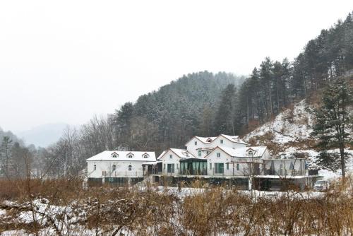 a house on top of a hill in the snow at Haneulbit gwangang nongwon in Chuncheon