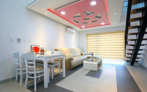 a living room with a couch and a table with chairs at Gyeongju the One Pension in Gyeongju