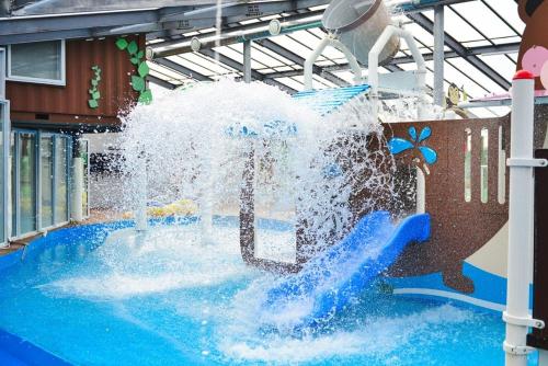a water fountain in a pool in a building at Vine family and kids four season pool villa in Gapyeong