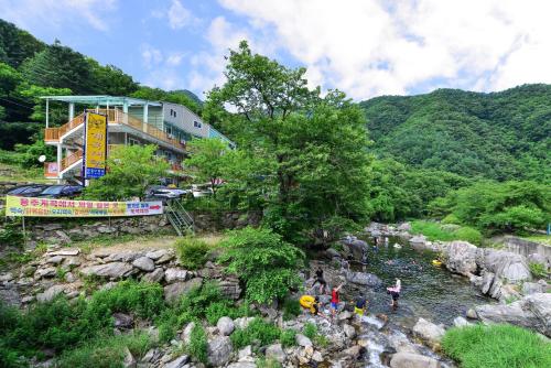 a group of people standing in a river at Gapyeong Yongchu Valley Travel Pension in Gapyeong