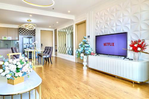 a living room with a large television and flowers at Classy Home - CSJ Tower Vũng Tàu, Luxury, Sky-Sea View and Walk-To-Beach in Xã Thang Tam
