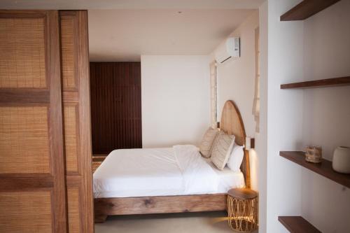 a bedroom with a white bed and a wooden door at Chantauvent Guest House in Blue Bay