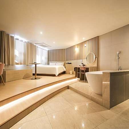 a large bathroom with a bed and a bath tub at Browndot Hotel Godeok newtown in Pyeongtaek