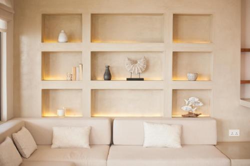 a living room with a white couch and shelves at Chantauvent Guest House in Blue Bay