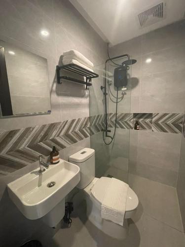 a bathroom with a white toilet and a sink at Maharlika City Inn in Bacolod