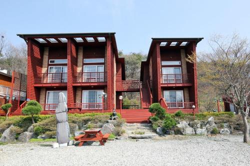 a large red building with a picnic table in front of it at Milart Pension in Taean