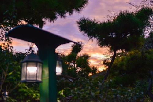 a street light and a lamp with a sunset in the background at Giltara HaengWoon Pension in Gapyeong