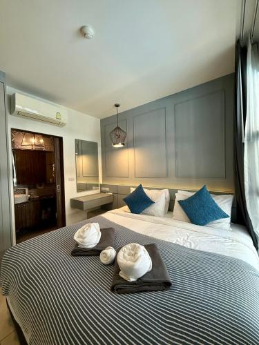 a bedroom with a large bed with two hats on it at Poolside 1 Bedroom Apartment by Renttini in Surin Beach