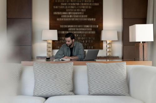 un homme assis à une table avec un ordinateur portable dans l'établissement JW Marriott Hotel Bogotá, à Bogotá