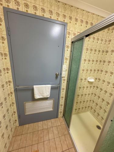a shower with a glass door in a bathroom at Pastoral Hotel Motel Echuca CBD in Echuca