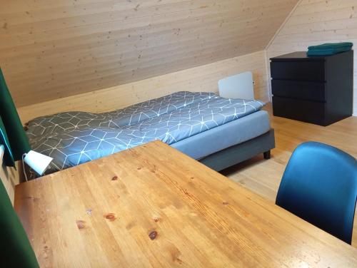 a room with a bed and a wooden table at Sowi Stok in Sokolec