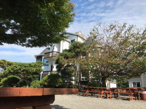a building with tables and benches in front of it at Anmyeondo Bada Sarang Naksi Pension in Taean