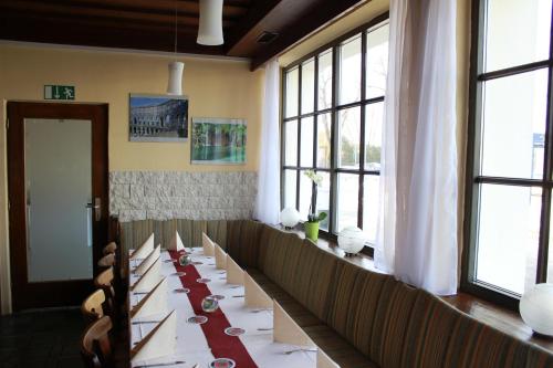 a dining room with a long table with white tablecloths at Motel Füssen im Allgäu in Füssen