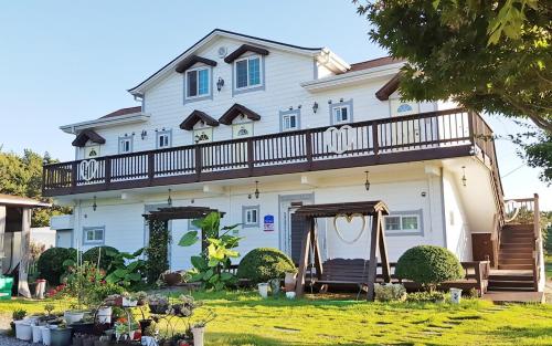 a large white house with a balcony on it at Poeguenhan Pension in Taean
