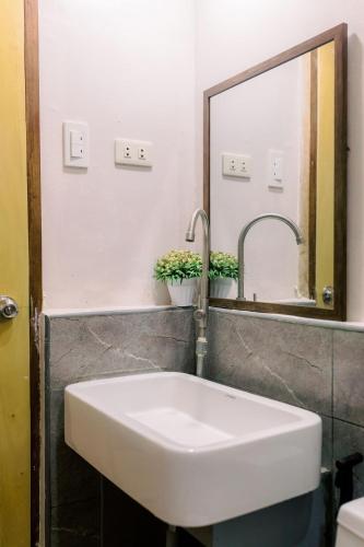 a white sink in a bathroom with a mirror at Busai Dream Falls Resort in Loboc