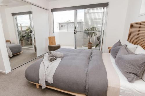 Un dormitorio con una cama grande y un espejo grande. en C & C By The Sea, en Coolum Beach
