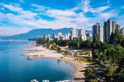 a beach in front of a city with tall buildings at Stunning Skyline Views in a Cozy and Stylish Abode in Vancouver