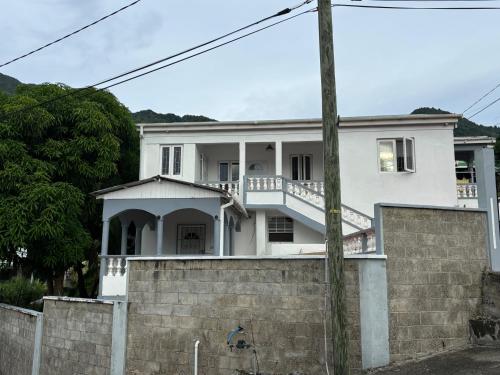 a white house with a brick wall at Tropical Paradise Retreat in Soufriere in Soufrière