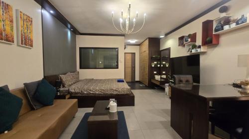 a living room with a couch and a bed at ARMO Nimman in Chiang Mai