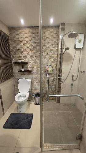 a bathroom with a toilet and a glass shower at ARMO Nimman in Chiang Mai