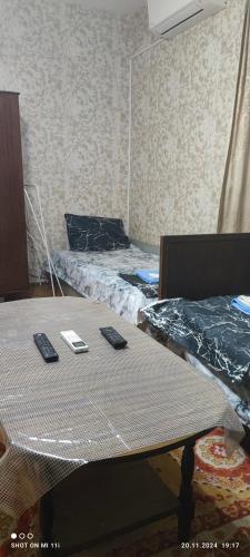 a room with two beds and two tables with remote controls at Апартамент in Razgrad