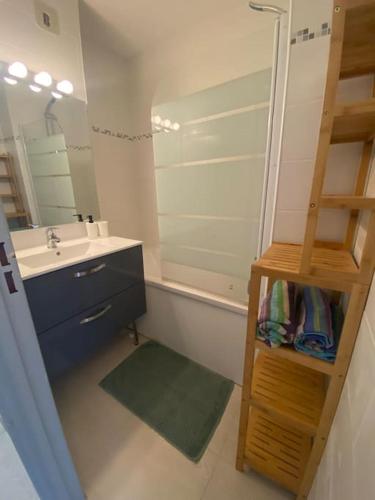 une salle de bain avec un lavabo et un miroir dans l'établissement Charmant 2 pièces climatisé à 50m de la plage, à Sète