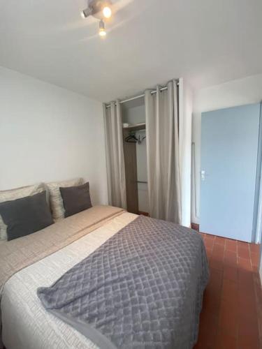 une chambre avec un lit et un ventilateur de plafond dans l'établissement Charmant 2 pièces climatisé à 50m de la plage, à Sète