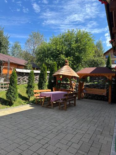 a picnic area with a table and a gazebo at Floare de Maramures 1 in Vadu Izei