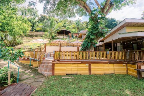 a house with a wooden deck with umbrellas at Busai Dream Falls Resort in Loboc