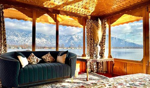 a couch in a room with a view of mountains at New Jacquline Heritage Houseboats in Srinagar