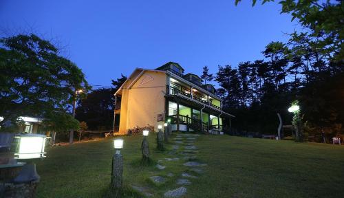 a large house with lights in the yard at night at Taean Secret Garden in Taean