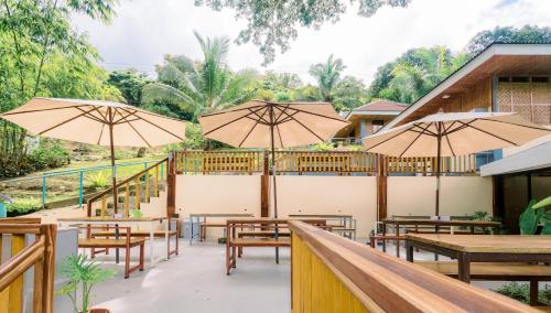 a patio with tables and umbrellas at a restaurant at Busai Dream Falls Resort in Loboc