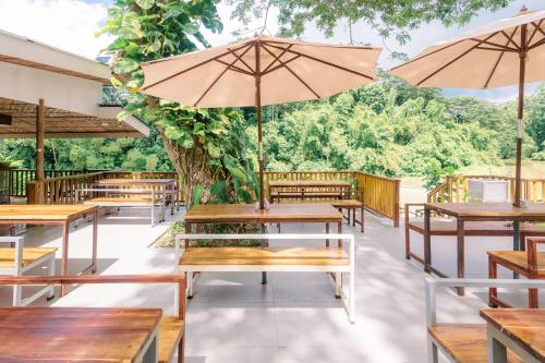 an empty restaurant with tables and umbrellas at Busai Dream Falls Resort in Loboc