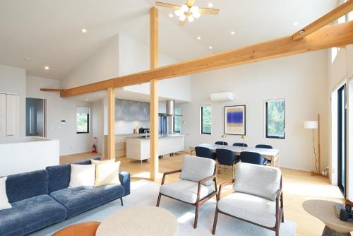 a living room with a blue couch and chairs at Hayama Ocean Villa - 南葉山 オーシャンヴィラ - in Yokosuka