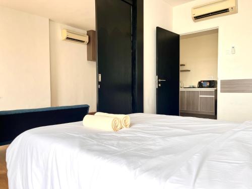 a bedroom with a white bed with a black door at Hillton Suites in Ayer Keroh