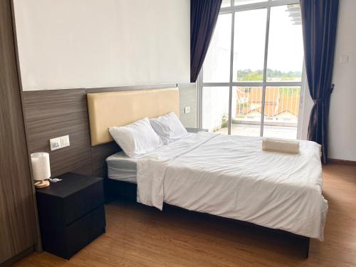 a bedroom with a bed and a large window at Hillton Suites in Ayer Keroh