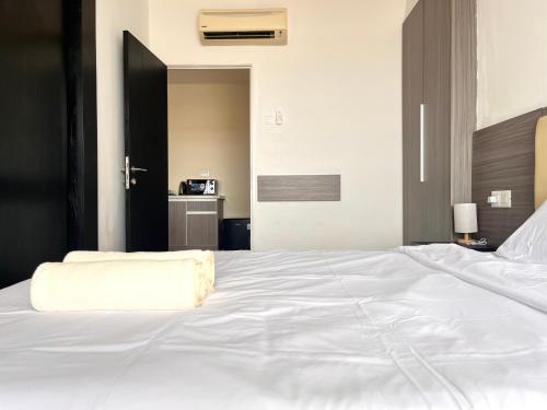 a large white bed with a white blanket on it at Hillton Suites in Ayer Keroh