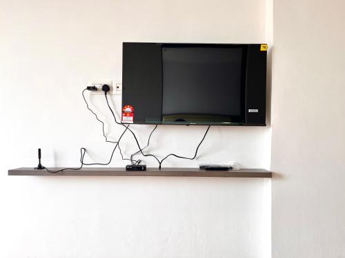 a flat screen tv hanging on a wall at Hillton Suites in Ayer Keroh