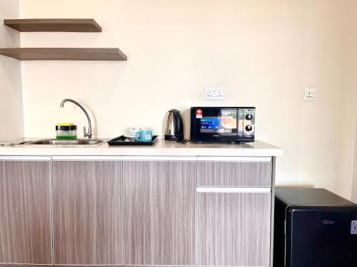 a kitchen with a counter with a microwave and a sink at Hillton Suites in Ayer Keroh