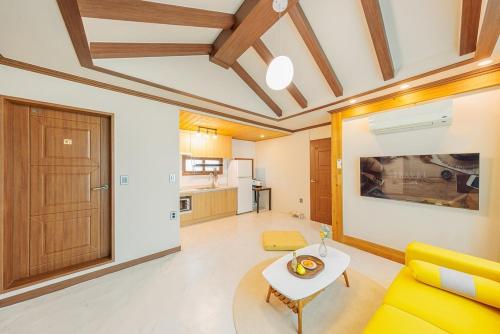 a living room with a yellow couch and a table at Gyeongju Helper pet Pension in Gyeongju