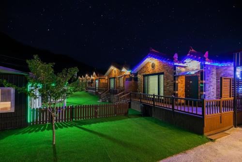 a house with a yard of green grass at night at Gyeongju Helper pet Pension in Gyeongju