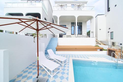 a house with a swimming pool and an umbrella at Hayama Ocean Villa - 南葉山 オーシャンヴィラ - in Yokosuka