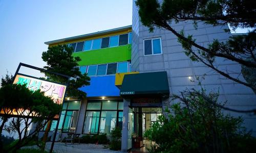 a building with a green stripe on the side of it at Buan Haeneomii Chukjae Pension in Buan