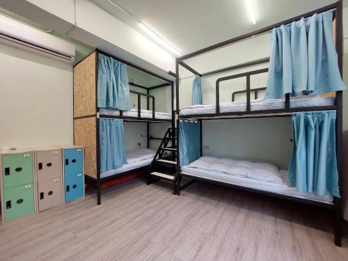 a room with three bunk beds and a ladder at On My Way - Taipei Hostel in Taipei